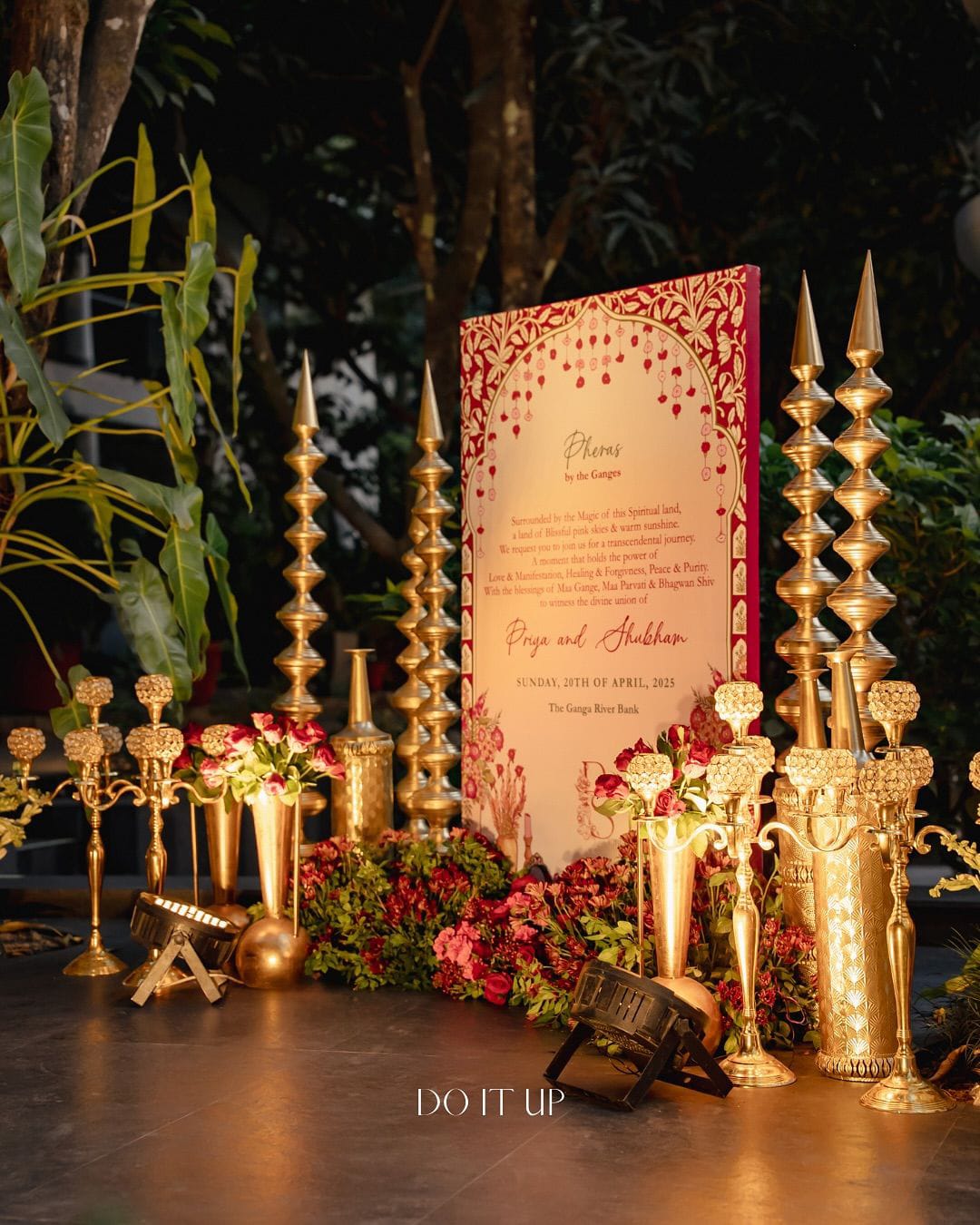 Wedding welcome signboard surrounded by golden spires, candelabras and red flowers