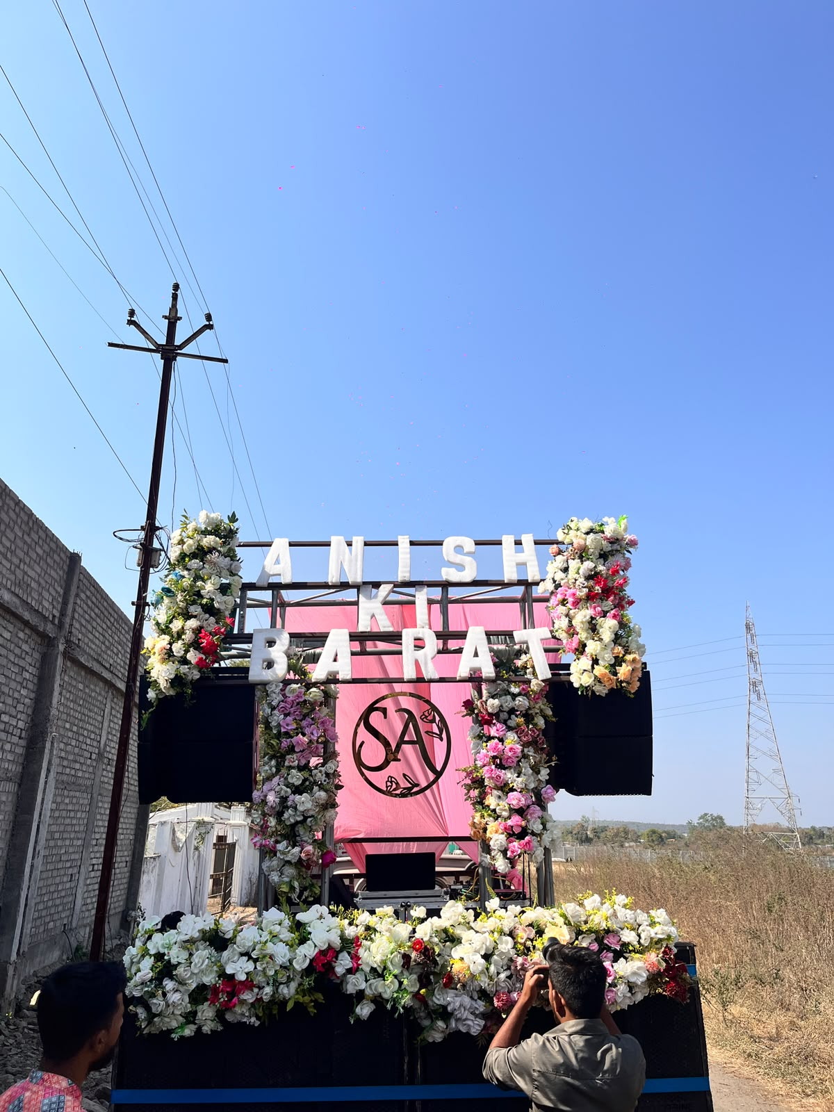 Baraat trolley with a pink backdrop framed by white and pink flowers