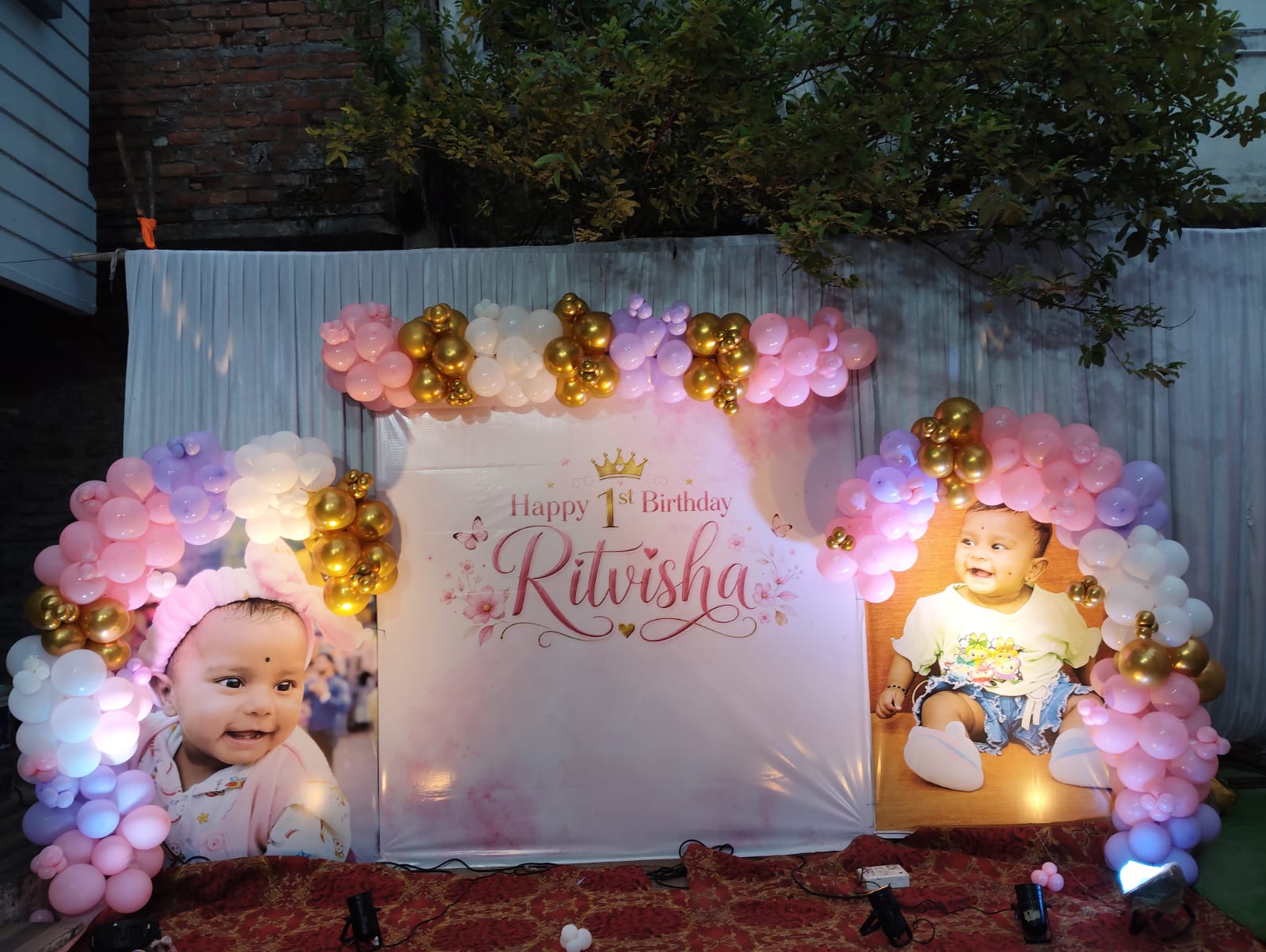 Baby birthday corner with a pastel balloon garland, cloud backdrops and a name banner
