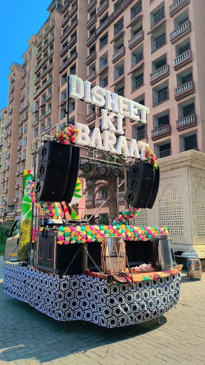 Decorated baraat DJ truck with a name sign, garlands and speaker stacks
