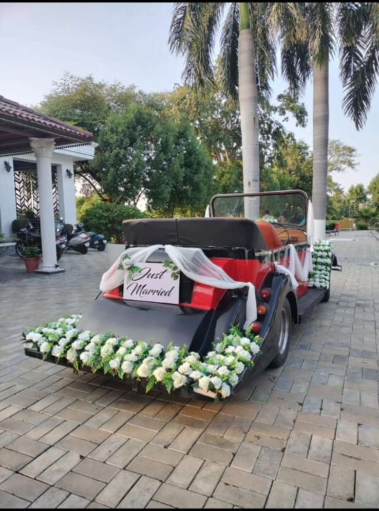 White vintage convertible decorated with green and white flowers for the baraat
