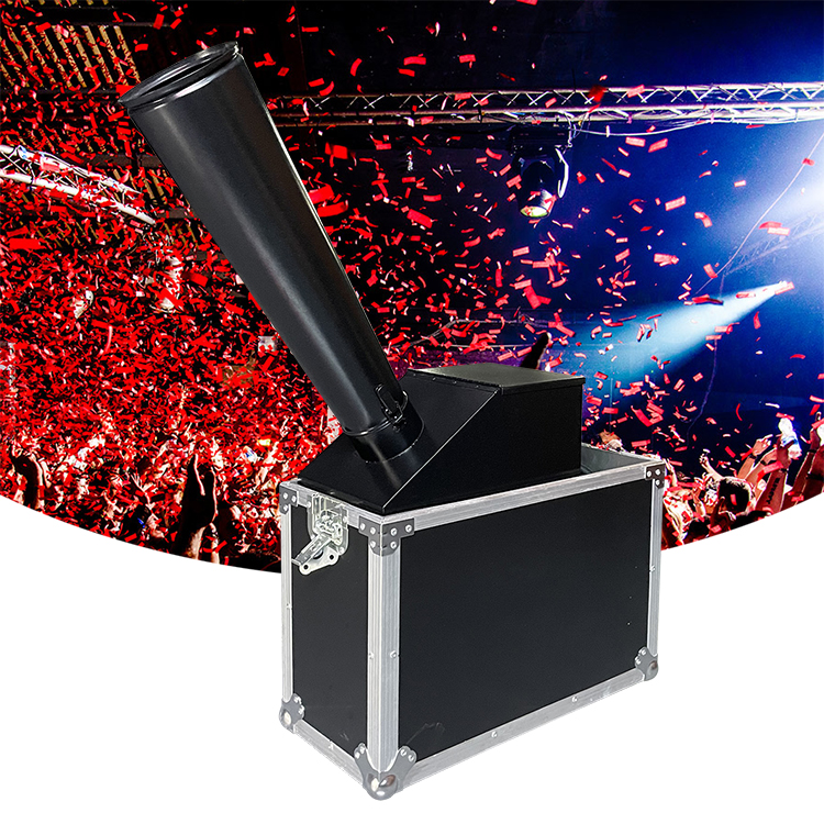 Black CO2 confetti blower machine in a silver flight case spraying red confetti across an event stage