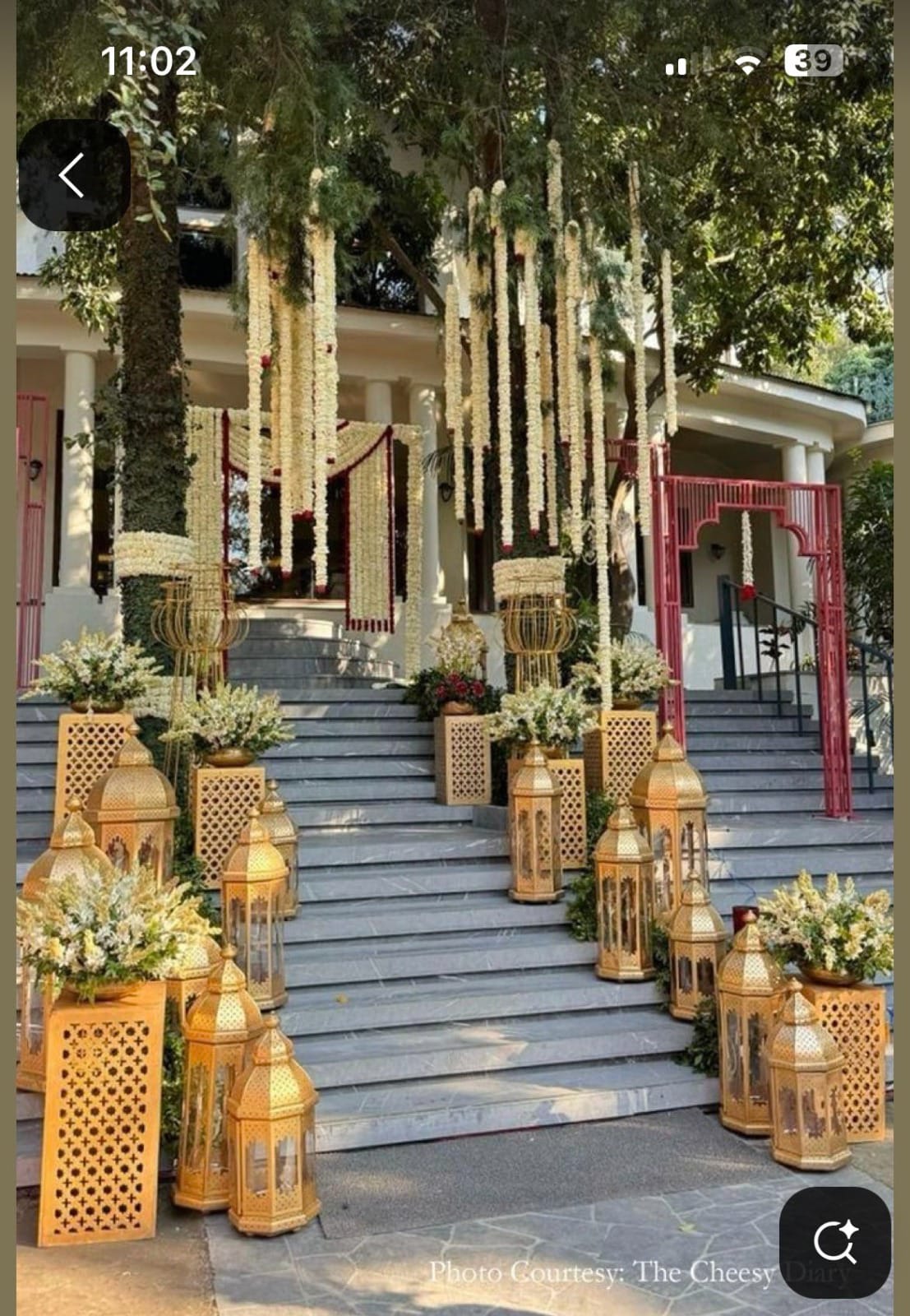 Entrance steps lined with brass lanterns, white flowers and hanging floral strings